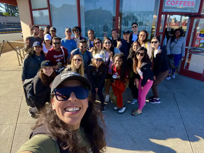 Zulma taking a selfie with a large Hike & Yap group outside a cafe in San Francisco