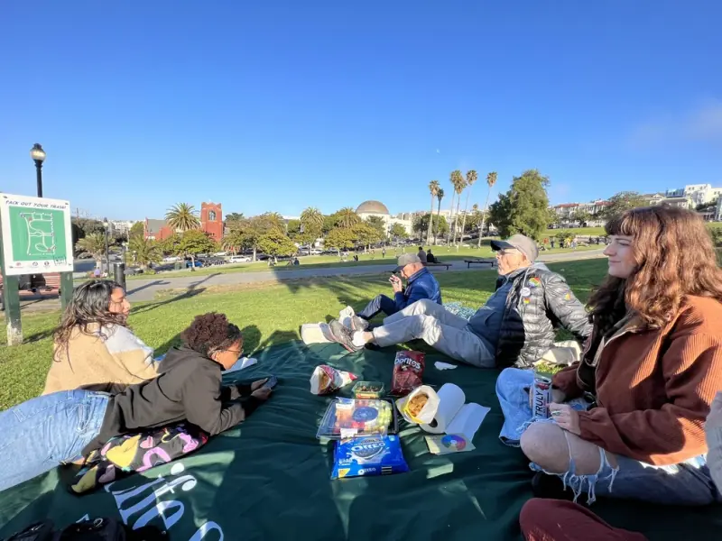 Community members relaxing together outdoors on a sunny day
